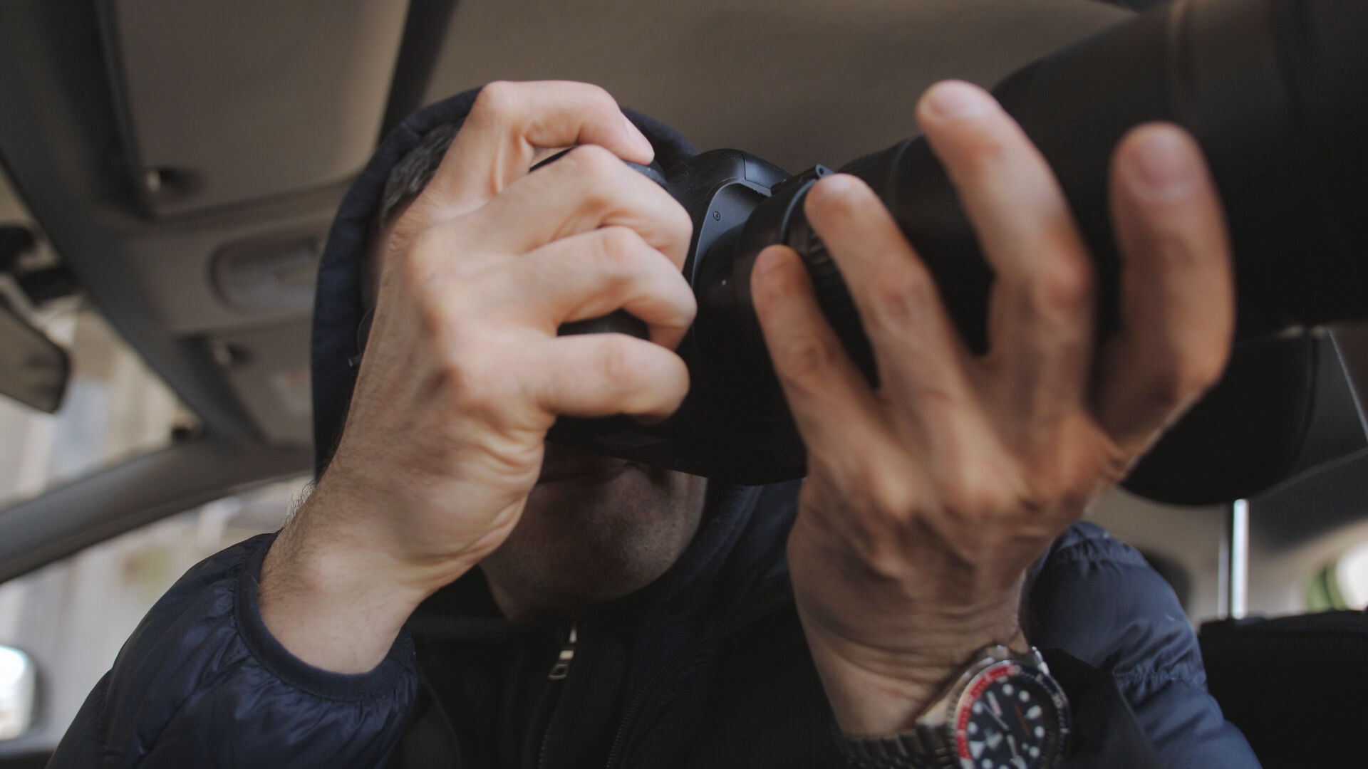 stalker in a hood taking a photo